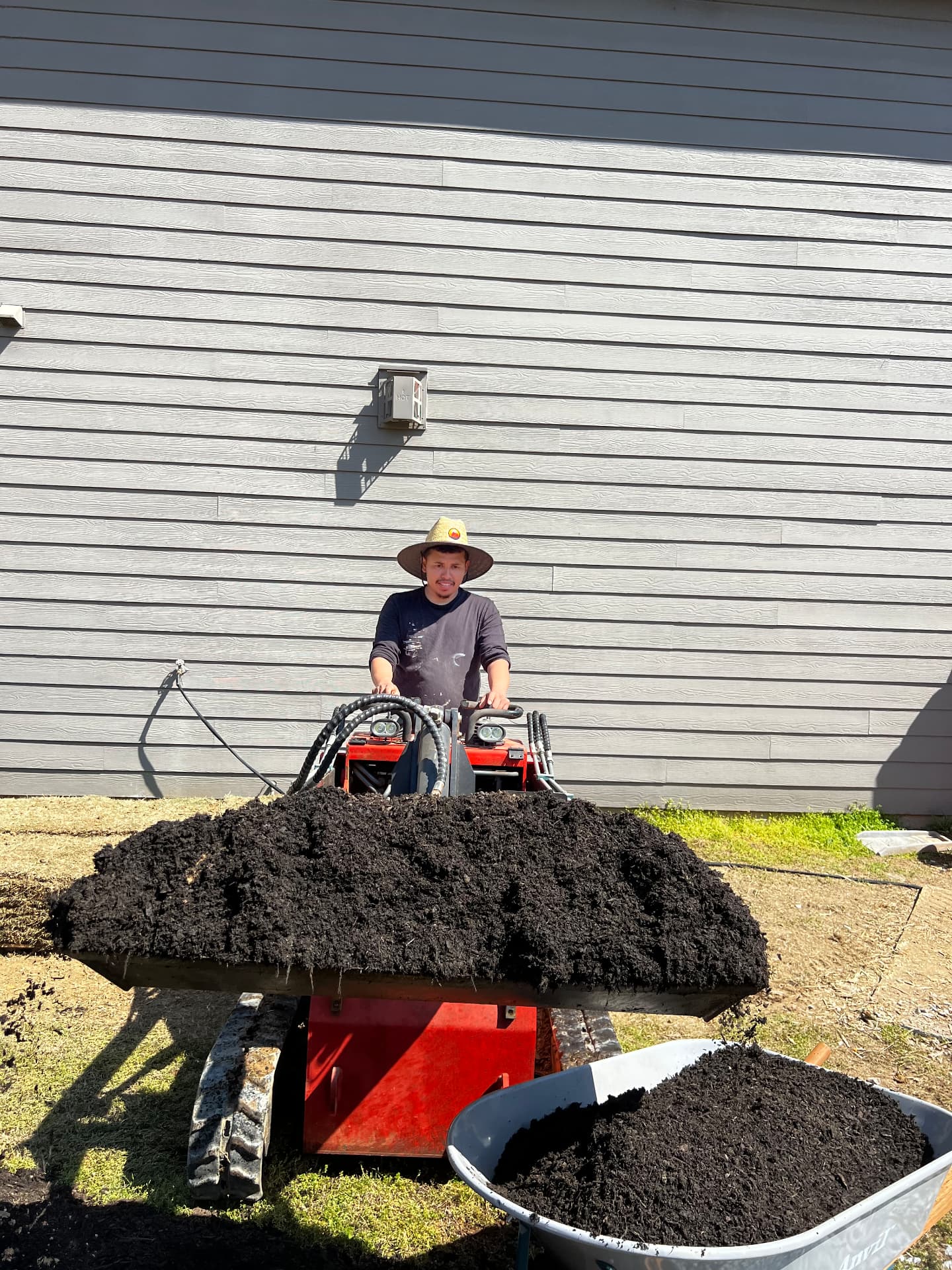 Crew spreading fresh mulch around a completed home