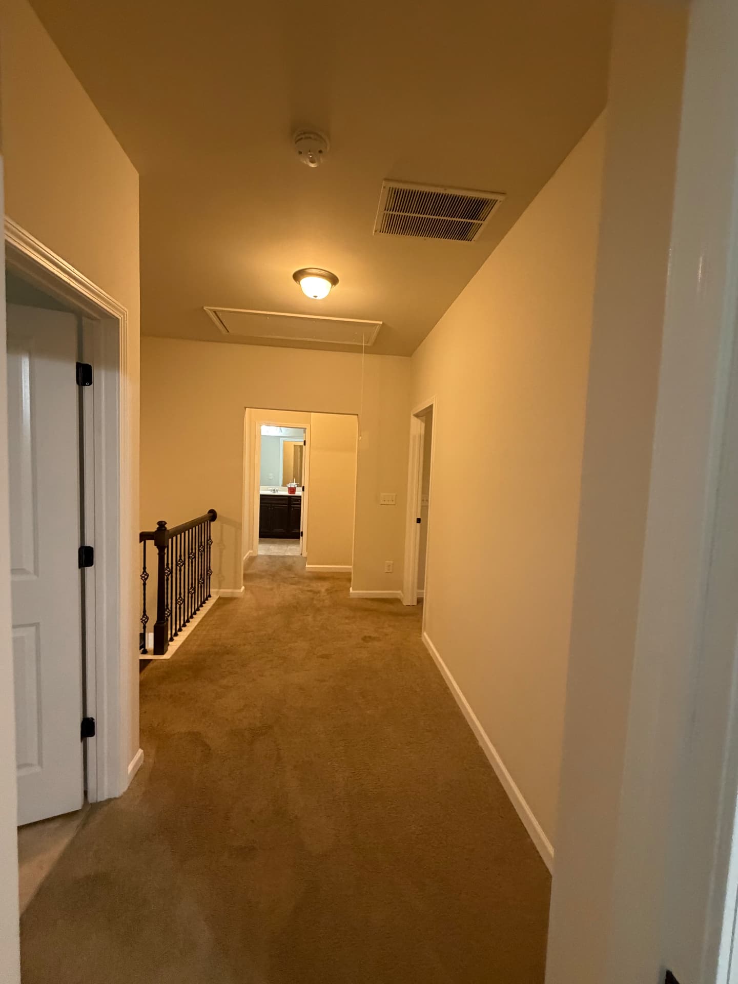 Upstairs hallway and landing with fresh pale walls, white doors, casing and baseboards