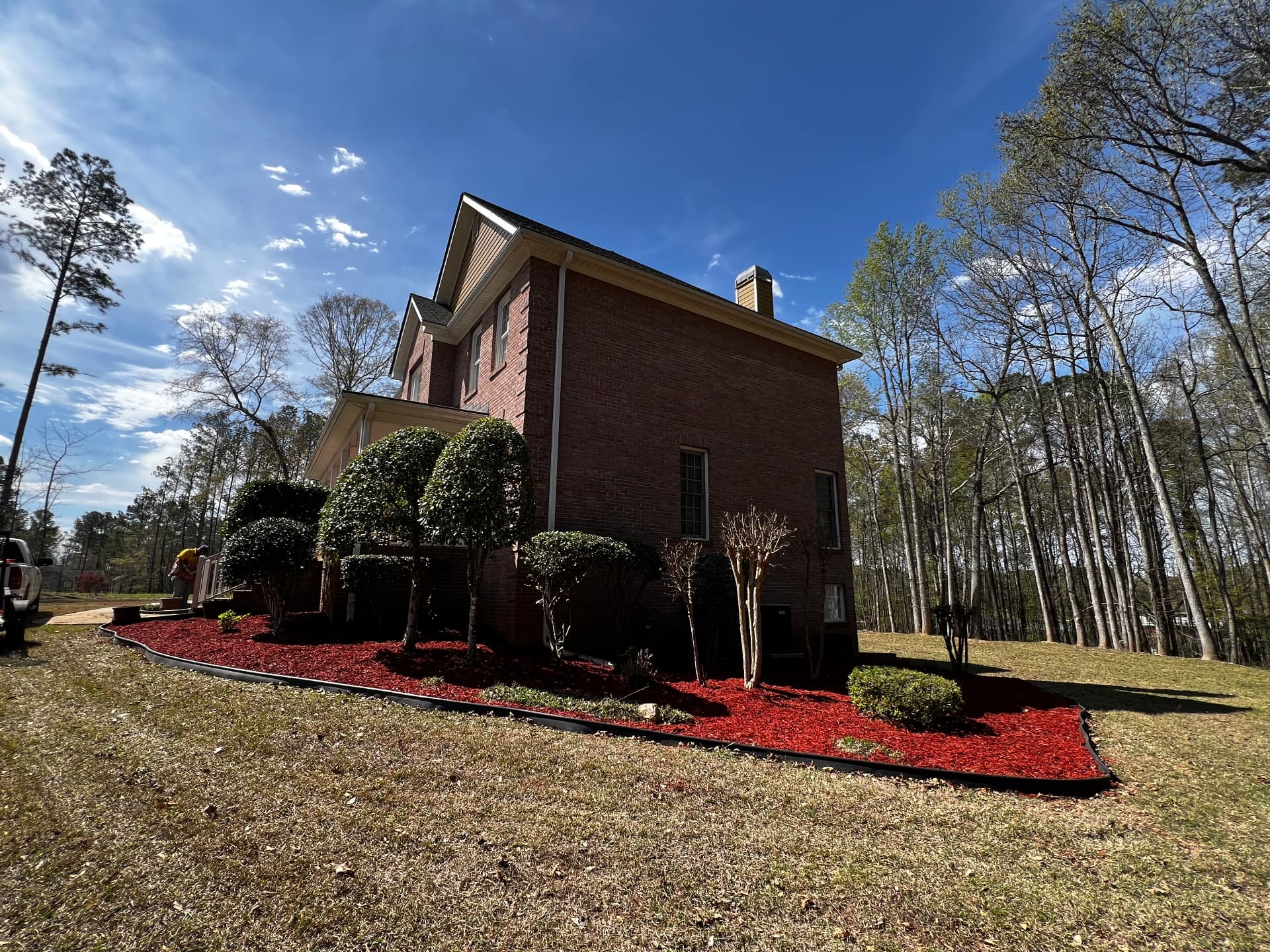 Finished planting beds with bright red mulch, crisp edging and trimmed shrubs