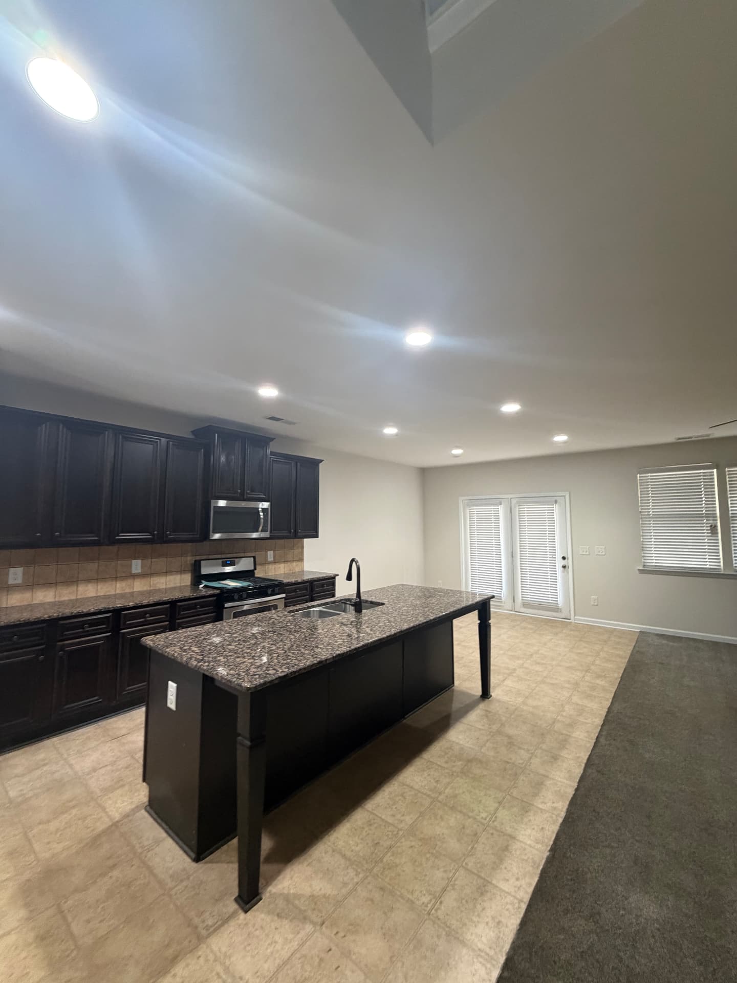 Kitchen and dining area with newly painted warm greige walls and dark cabinets