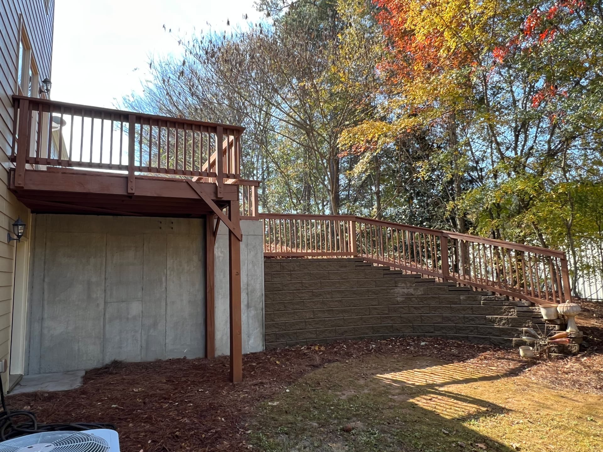 Stained deck posts and beams above a clean concrete foundation wall