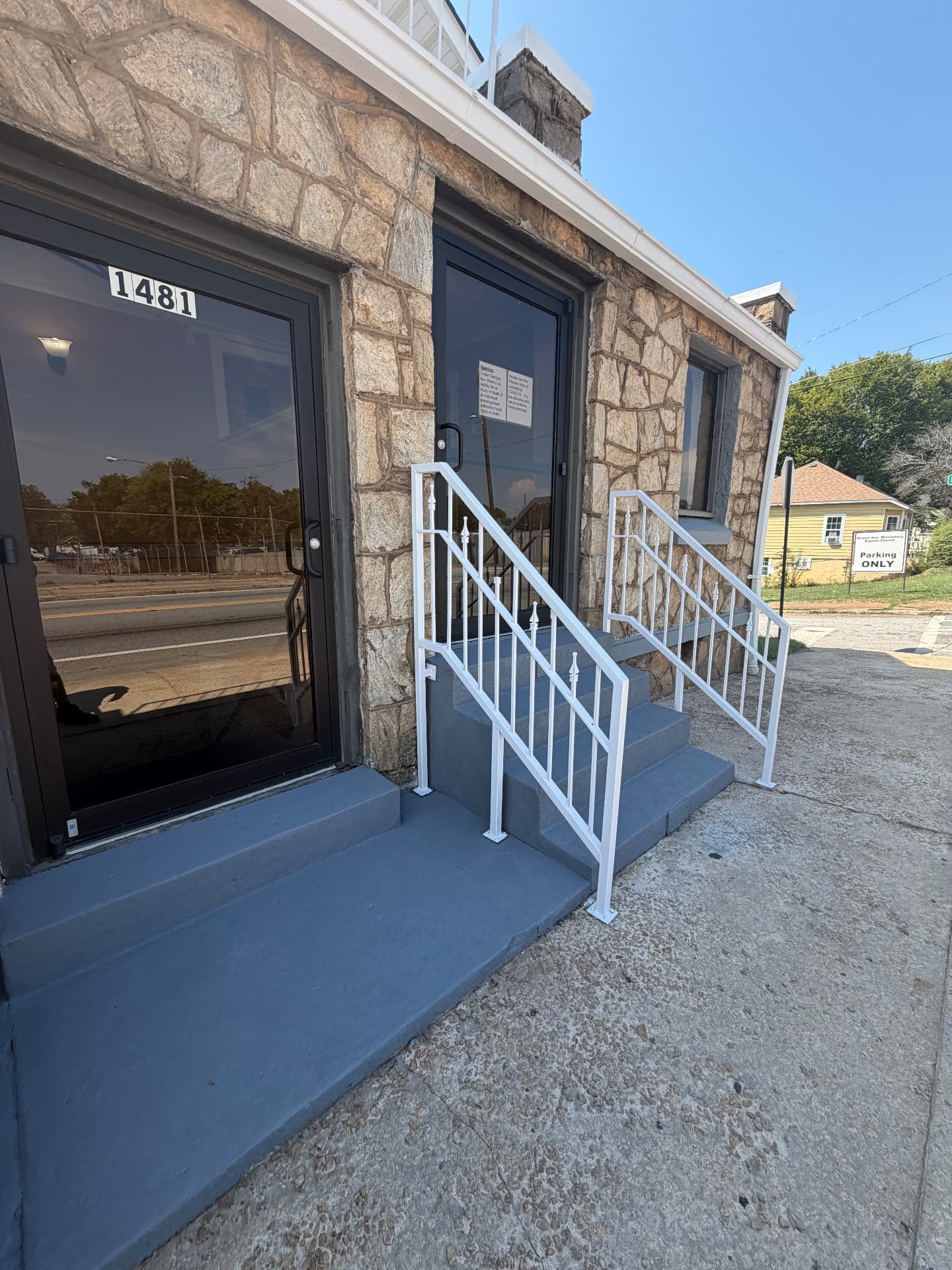 Completed entrance with fresh gray steps, glass doors and white metal railings