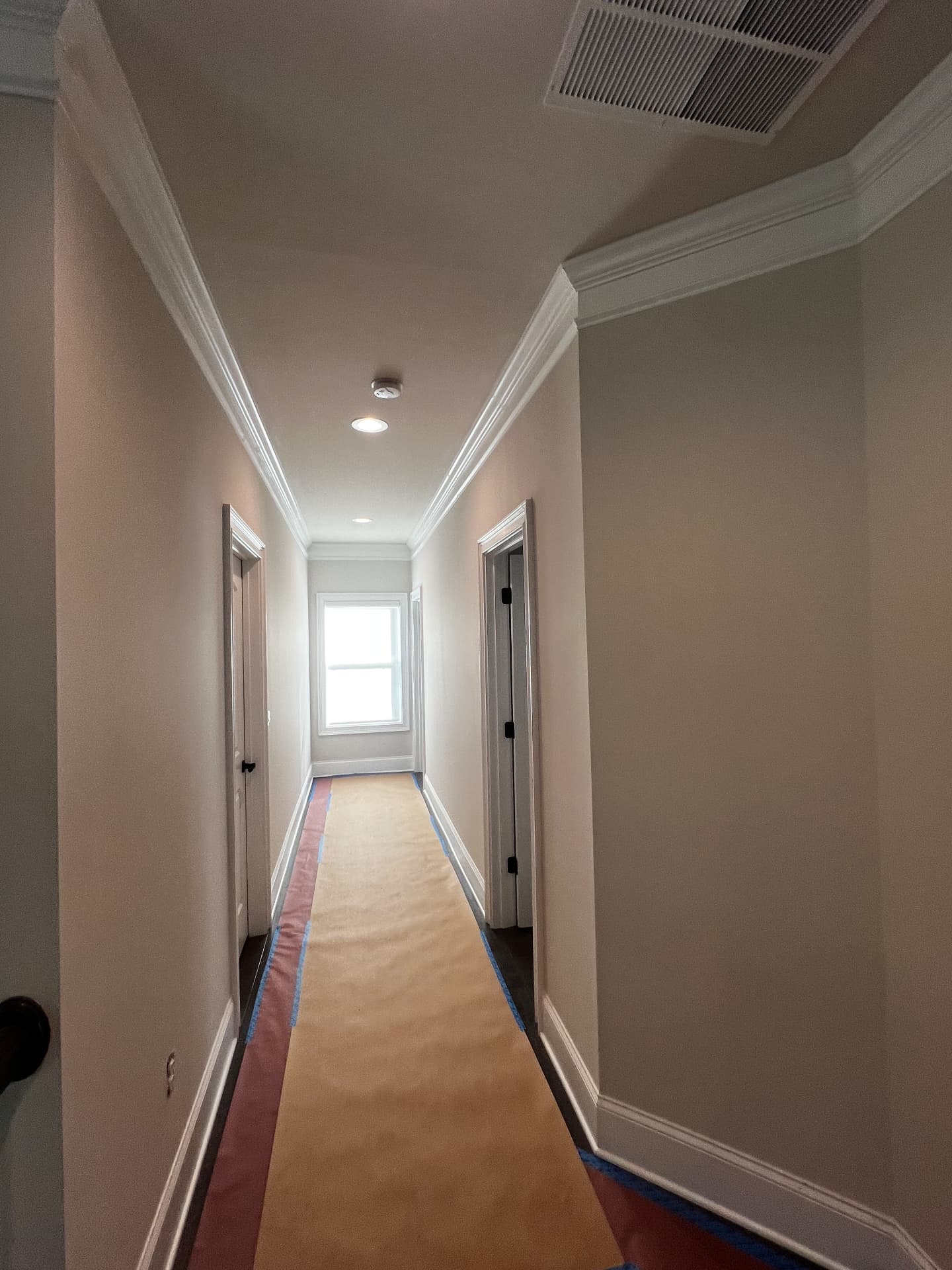 Upstairs hallway with fresh warm walls and white crown moulding