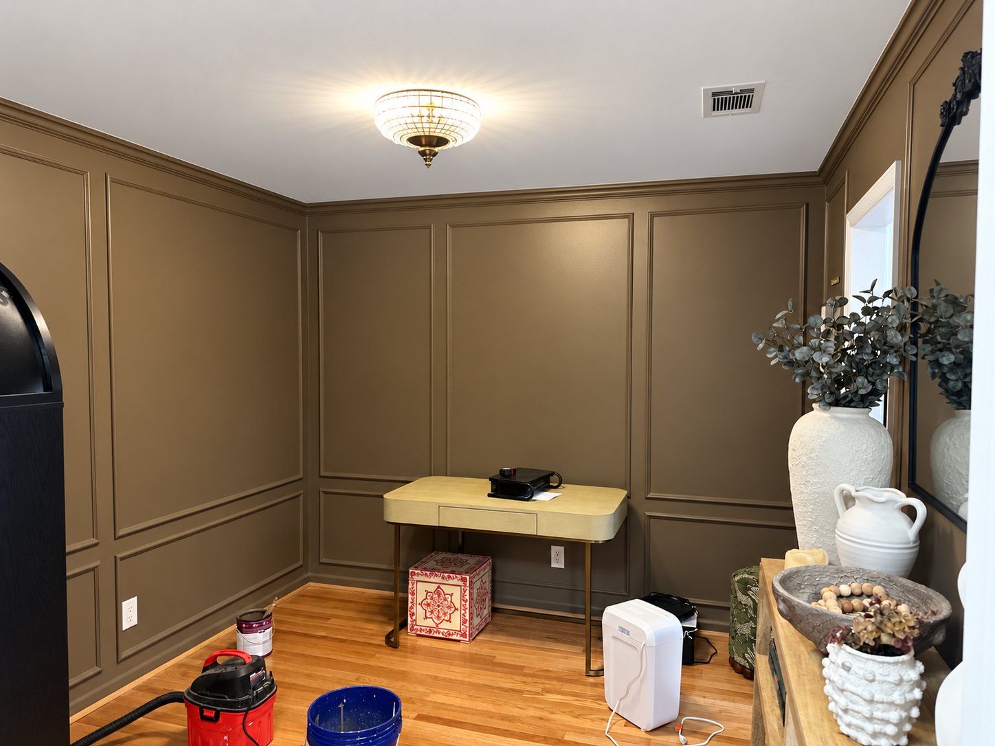 Finished room with deep warm brown walls and matching trim, white ceiling and hardwood floors